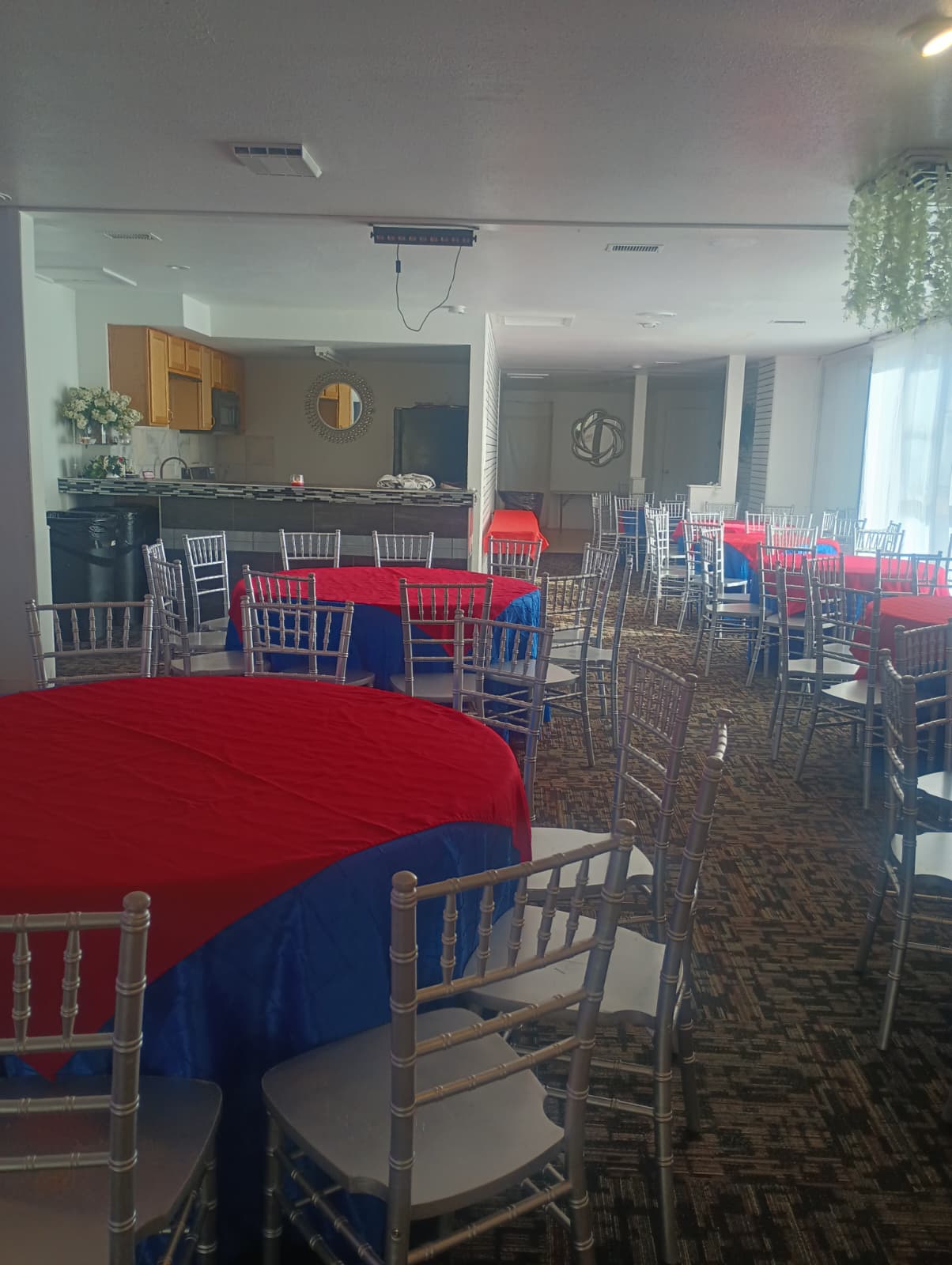 Salón montado con mesas rojas y azules